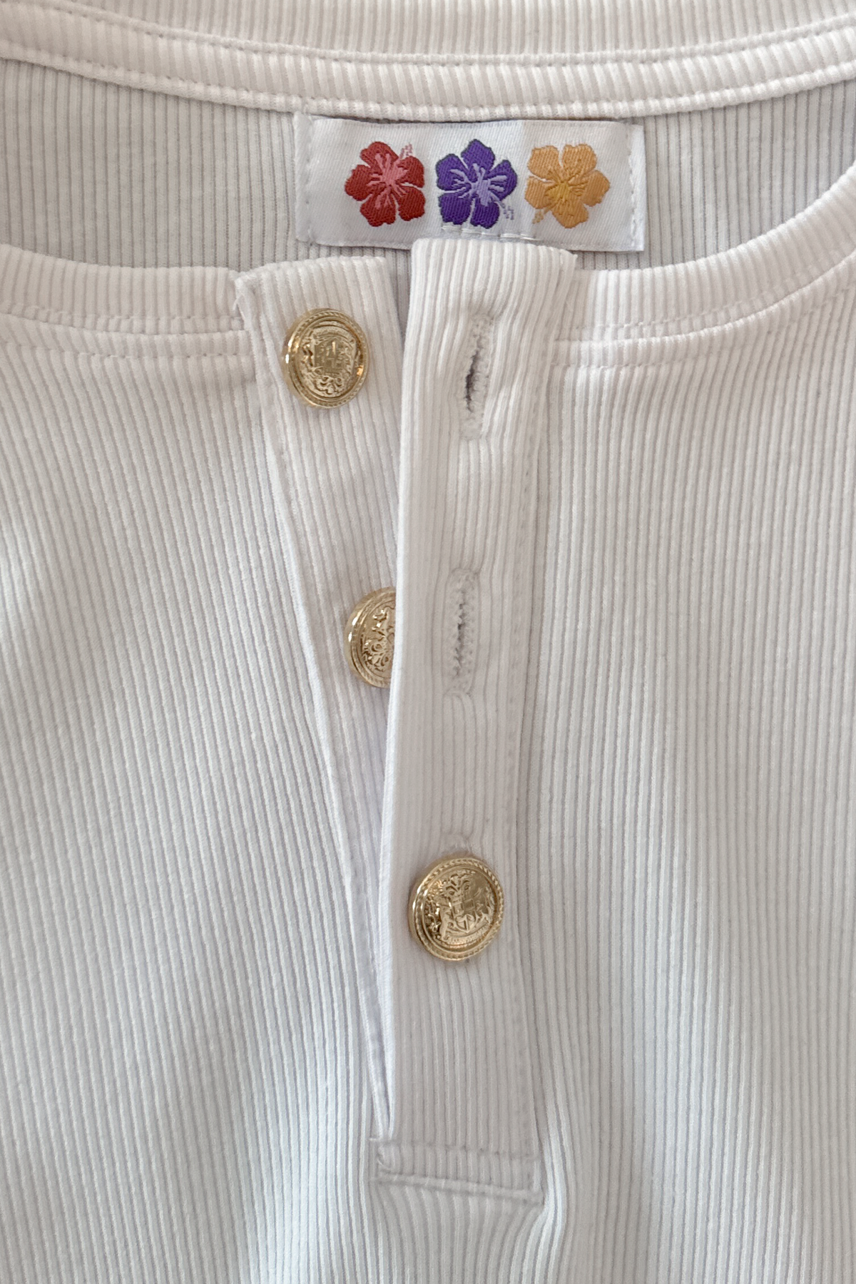 Close-up of the custom-made buttons on the white Henley Shortsleeve